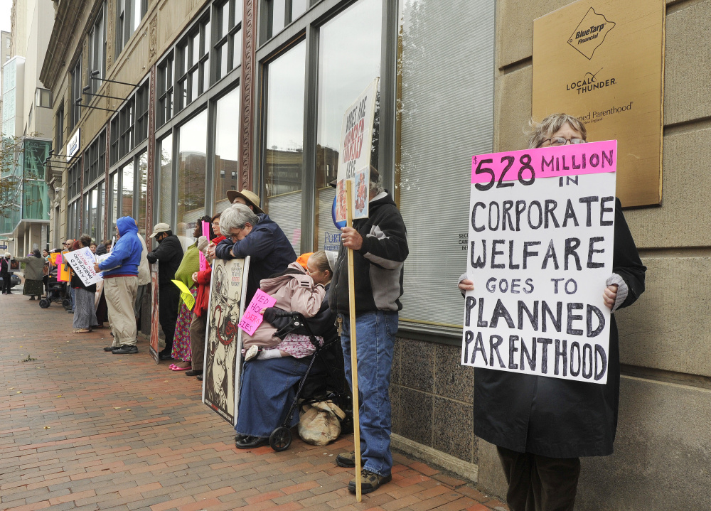 Anti-abortion activists hold a protest outside the doors of the Planned Parenthood office on Congress Street in Portland on Saturday.
