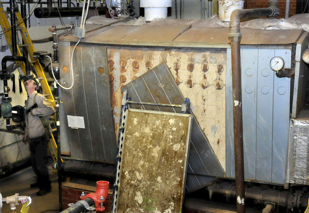 One of two large oil furnaces will soon be replaced with a single, small heat exchanger for the biomass heating system in Scott Hall dormitory at the University of Maine at Farmington.