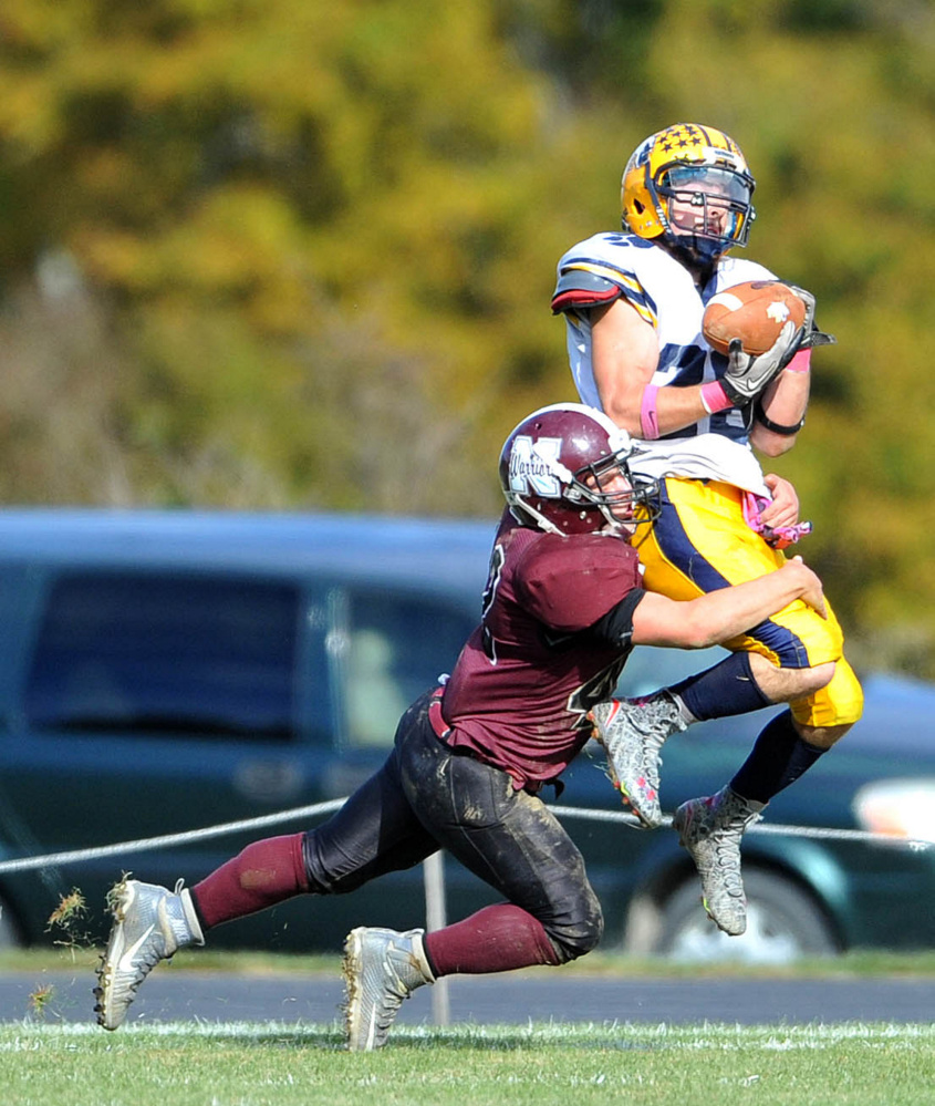 Mt. Blue High School’s Christian Whitney (28) catches the ball as Nokomis High School’s Cody Rice (42) defends on Saturday in Newport.