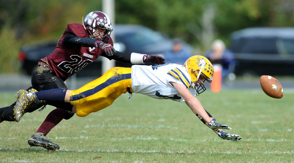 Mt. Blue High School’s Nate Pratt-Whitney (14) dives for the ball as Nokomis High School’s Colby Pinette (20) defends on Saturday in Newport.