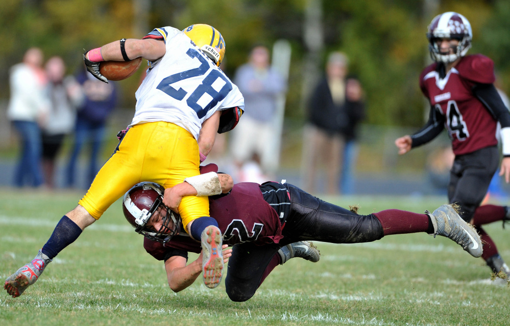 Nokomis High School’s Cody Rice (42) dives to tackle Mt. Blue High School’s Christian Whitney (28) on Saturday in Newport.