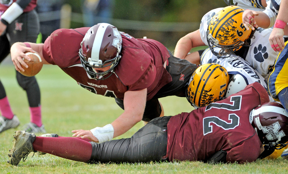 Nokomis High School’s Alex Chapman (74) dives for extra yards as Mt. Blue High School’s Leo Flannery (51) and Adam Mealey (65) defend Saturday in Newport.