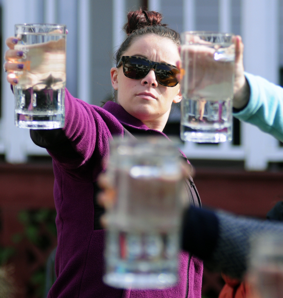 Kaitlin Sweeney holds up a 44-ounce mug as she competes in the stein hoisting contest during harvest festivities on Saturday in Belgrade Lakes village.