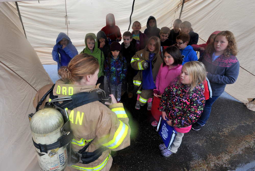 Firefighter Nancy Otis shows fourth-graders how her personal safety equipment works during a fire safety course at Canaan Elementary School in Canaan on Friday.