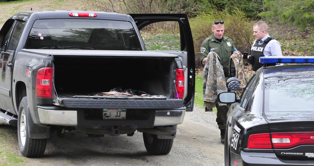 Game warden Dave Ross, left, and Winslow Detective Ryan McGowen look over turkey hunting gear belonging to the Janice and Reginald Jacques on May 5, after Janice Jacques accidentally shot Reginald while turkey hunting. Janice Jacques pleaded guilty to misdemeanor charges last month.