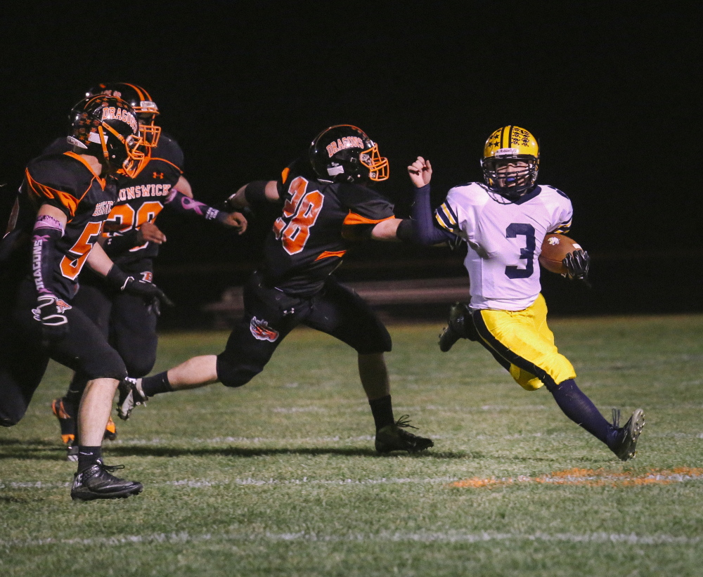 Mt. Blue’s Ryan Pratt looks for an opening in Brunswick’s defense in a game last season at Brunswick High School. Both the Cougars and the Dragons have a shot at the No. 1 seed in the postseason this year.