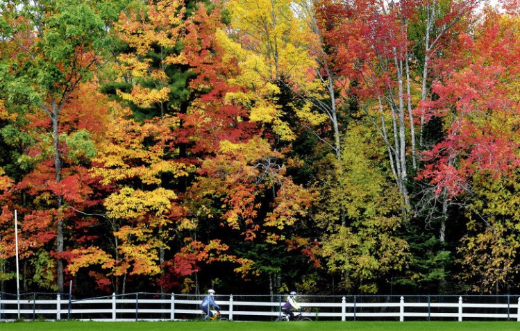 The fall foliage was out in force as Marie Mallet, left, and Meghan Southworth bike along a trail at the Field of Dreams complex in Unity on Sunday. Far northern Maine just hit “peak foliage” with 75 percent to 100 percent of trees in full fall regalia last weekend, which is two weeks behind last year and one to two weeks later than normal, according to the Maine Department of Agriculture, Conservation and Forestry’s fall foliage website.