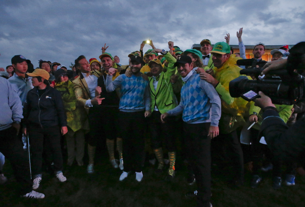 International team player’s Branden Grace and Louis Oosthuizen are surrounded by fans after they won their four ball match in fading light at the Presidents Cup at the Jack Nicklaus Golf Club Korea in Incheon, South Korea on.