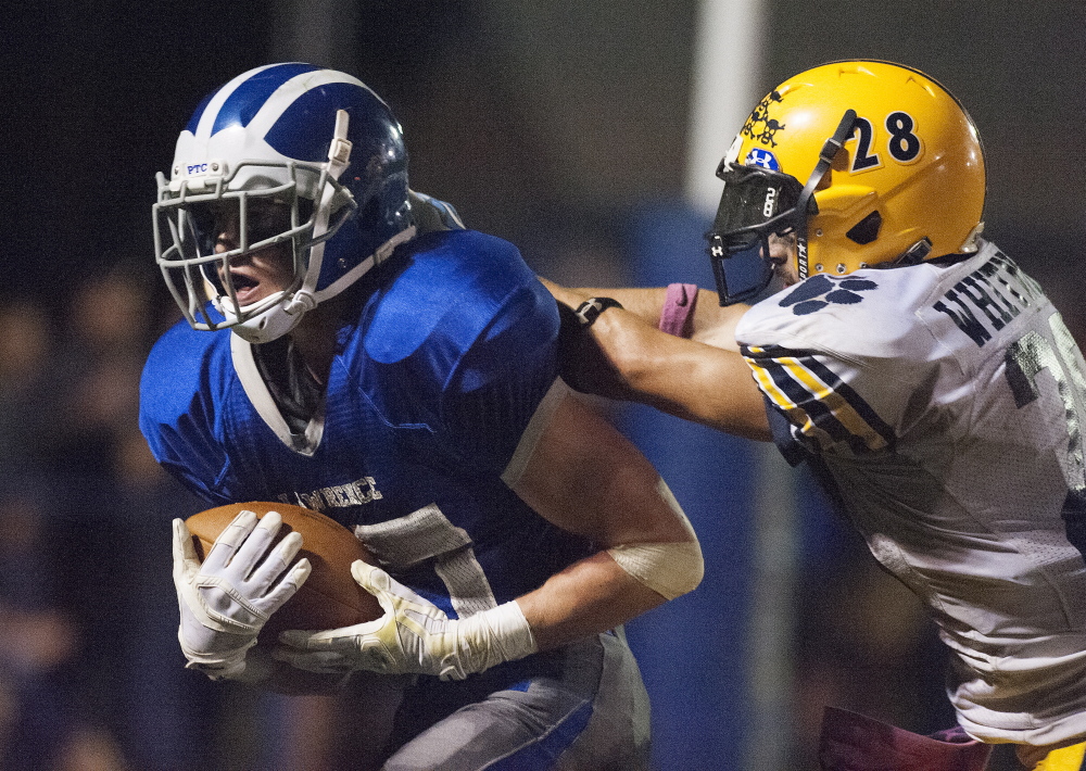 Lawrence running back Seth Powers fights off Mt. Blue’s Christian Whitney to reach the end zone during a Pine Tree Conference Class B game this season.