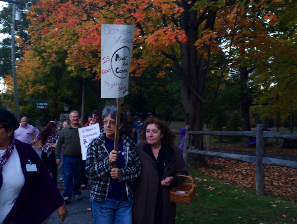Pat Woodward, left, of Madison, and Pam Morin, right, of Readfield, walk down Water Street in Skowhegan on Wednesday night as part of a domestic violence awareness vigil that started in Coburn Park and proceeded to the Skowhegan Town Office.