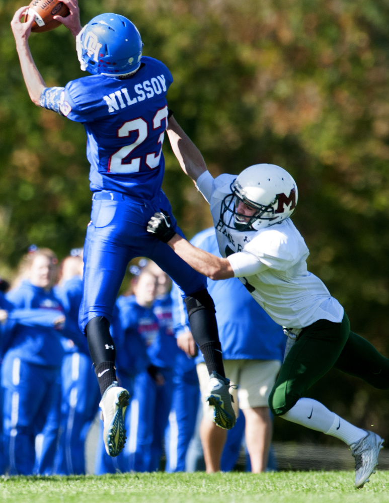 Staff file photo by Joe Phelan 
 Oak Hill wide receiver Connor Nilsson, left, catches a pass in front of Winthrop/Monmouth defender Ben Ames during a game last season.