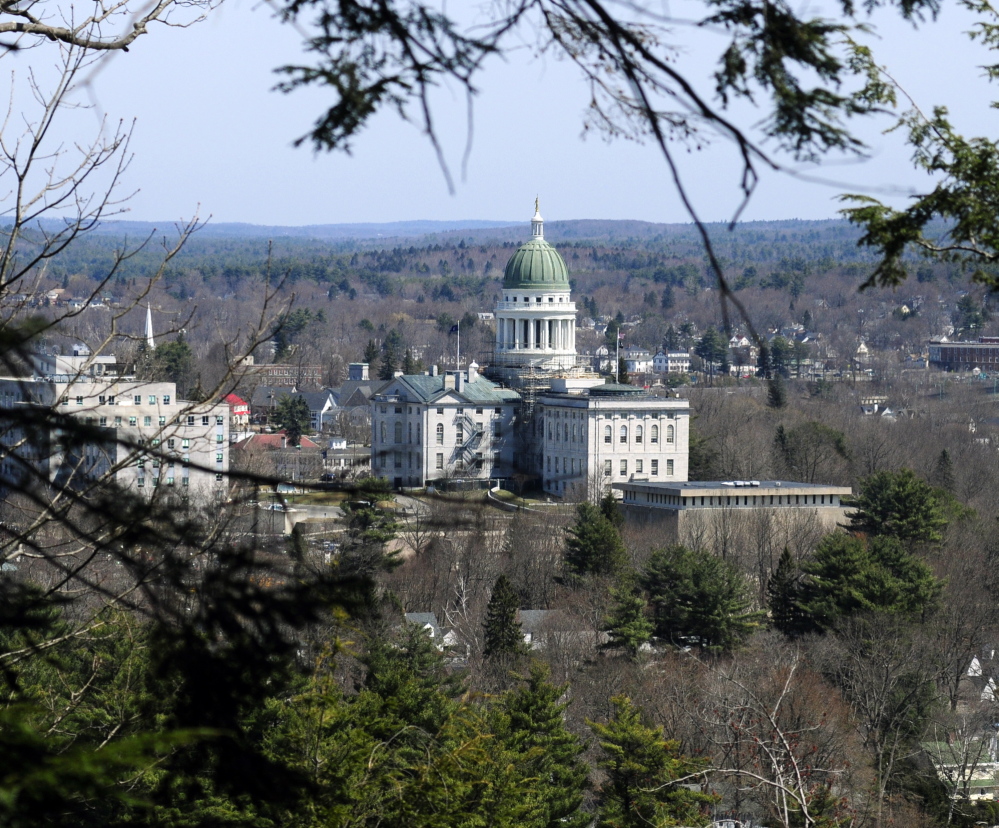 The State House complex appears through trees at the top of Augusta’s Howard Hill during a walking tour of the land on April 18. The wooded hill forms a backdrop to the State House.