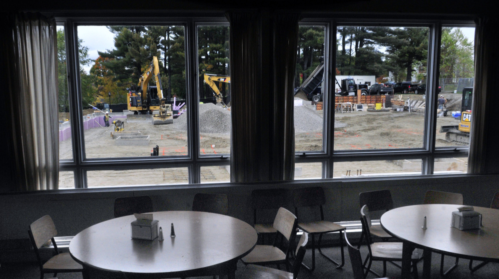 Construction work on the new dining hall is seen framed through windows of Masterman Union, the school’s current dining hall, on Friday at Kents Hill School in Readfield.