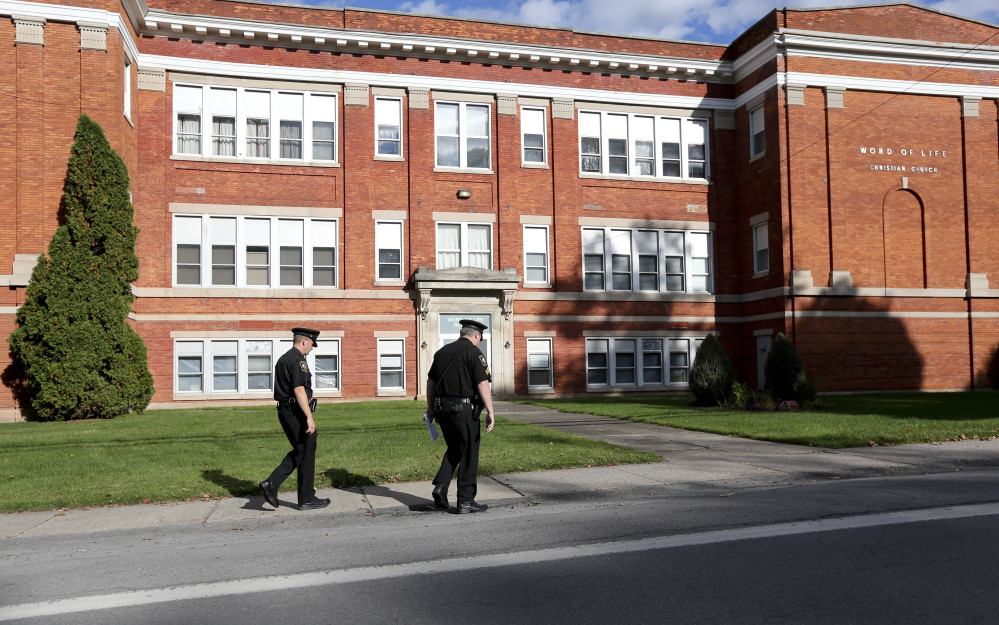 Police walk outside the Word of Life church on Thursday in New Hartford, N.Y.