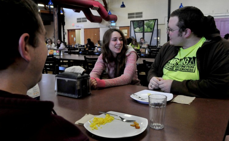 Veronica Manasco, a student at the University of Maine at Farmington, jokes Thursday with students Joshua Conley, left, and Cole Williams in the college cafeteria where Manasco works in the kitchen when not in class.