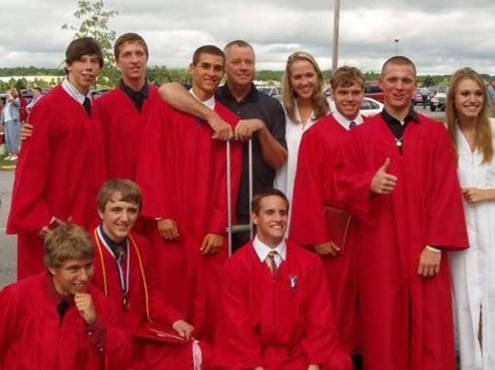 Contributed photo/Harmon family 
 Taylor Harmon, back, poses with members of the 2010 Cony High School graduating class. Harmon, a longtime Cony indoor track and field coach and supporter of student-athletes, died Sunday. He was 70.