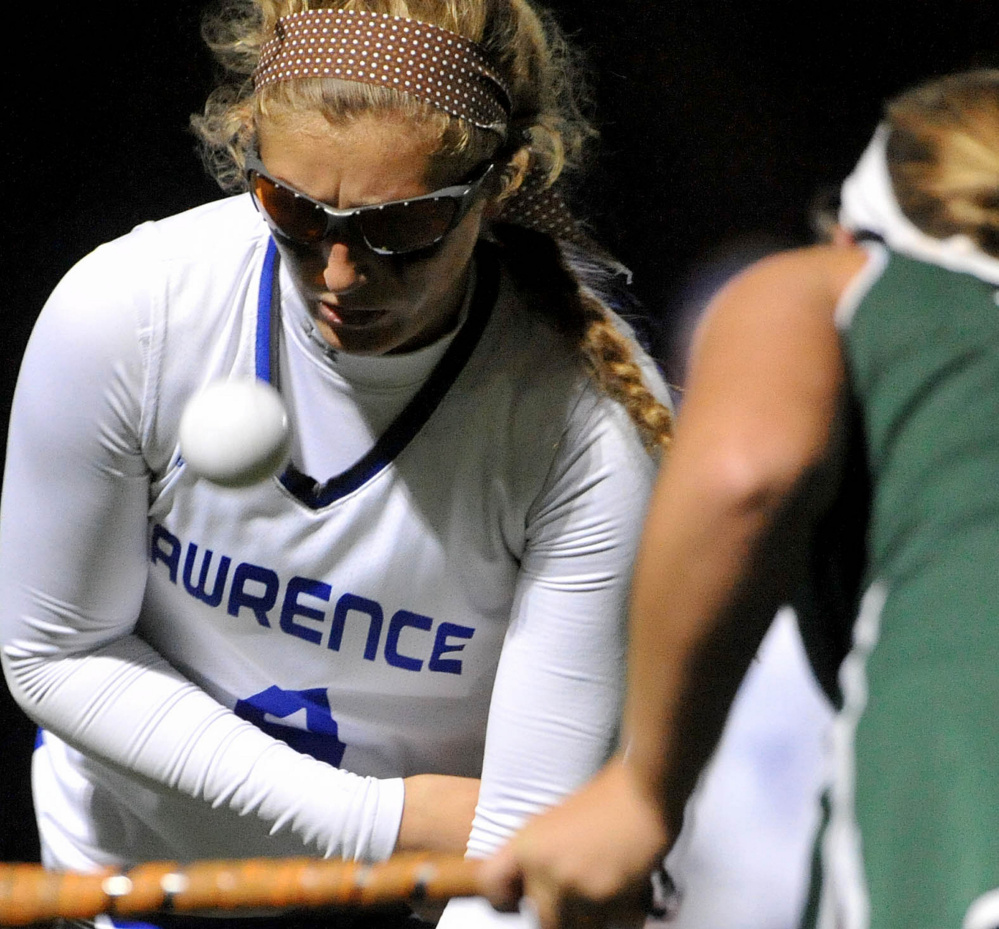 Staff photo by Michael G. Seamans 
 Lawrence's  McKenna Rogers keeps her eye on the ball as Old Town's Kaileigh Bell tries to clear it during the second half of a Class B North quarterfinal game Tuesday night at Thomas College.