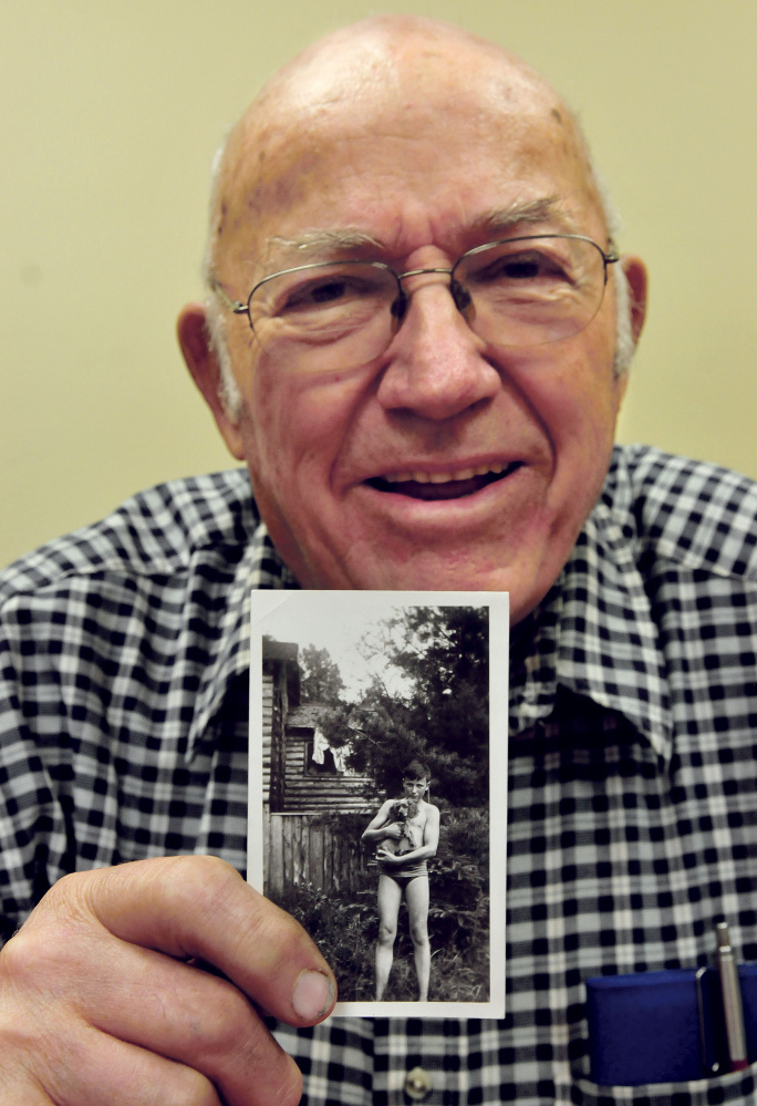 Robert McQuillan holds a photo taken of him in 1942, when he and family owned a cottage in Sidney on Messalonskee Lake, a few camps down from Charles Terry’s family. He and his brother, John, remember Terry as a troublemaker. Terry was later convicted of murder.