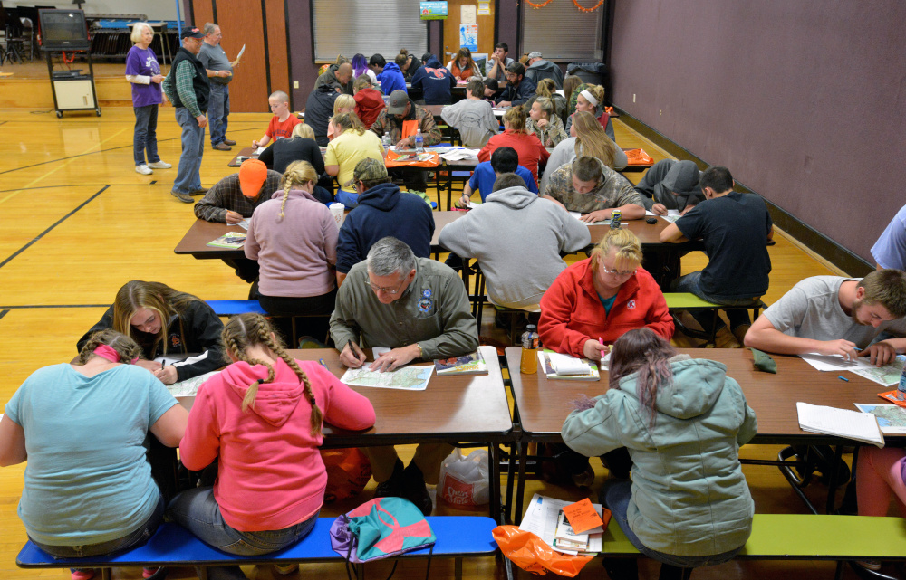 People participating in a hunter safety course Wednesday at Harmony Elementary School learn the finer points of map and compass use.