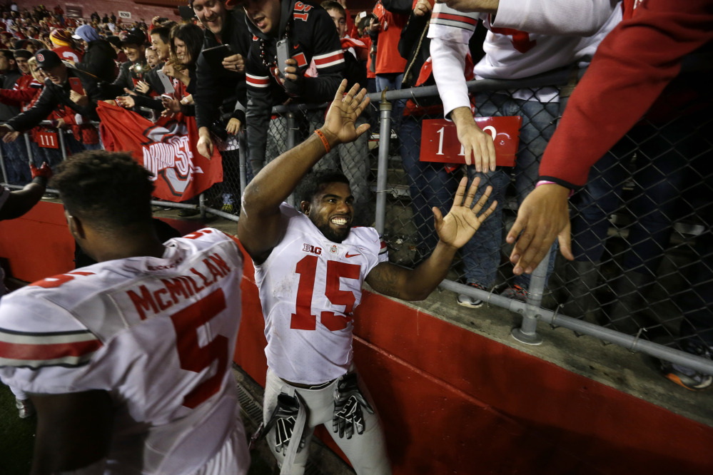 Ohio State running back Ezekiel Elliott (15) and linebacker Raekwon McMillan (5) greet fans on the field after a game against Rutgers on Saturday in Piscataway, N.J. Ohio State won 49-7 and remains No. 1 in the AP poll.