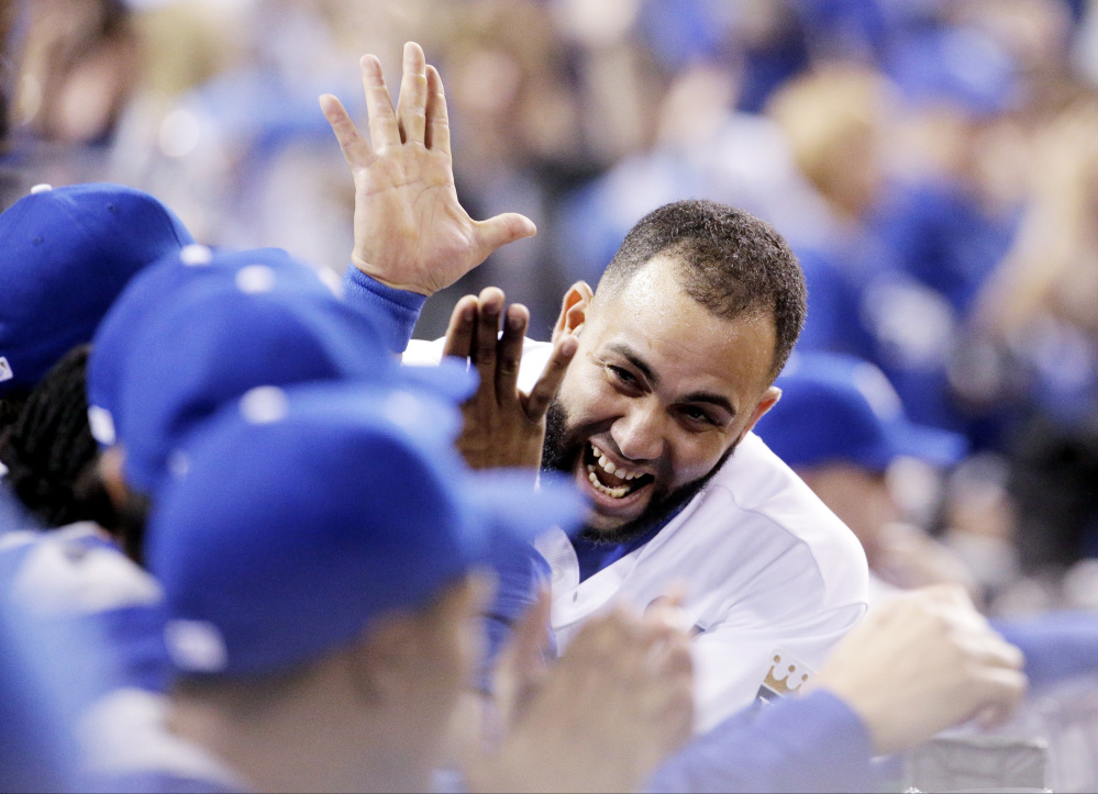 Kansas City’s Kendrys Morales celebrates Mike Moustakas’s home run against the Toronto Blue Jays during the second inning in Game 6 of the American League Championship Series on Friday in Kansas City, Mo.