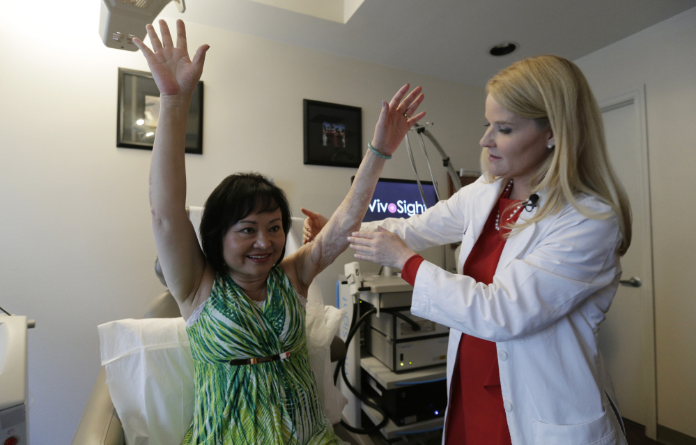 Dr. Jill Waibel examines Kim Phuc in Miami before the first of several laser treatments to reduce pain from burns Phuc received more than 40 years ago when her village in Vietnam was hit by an errant napalm bomb.