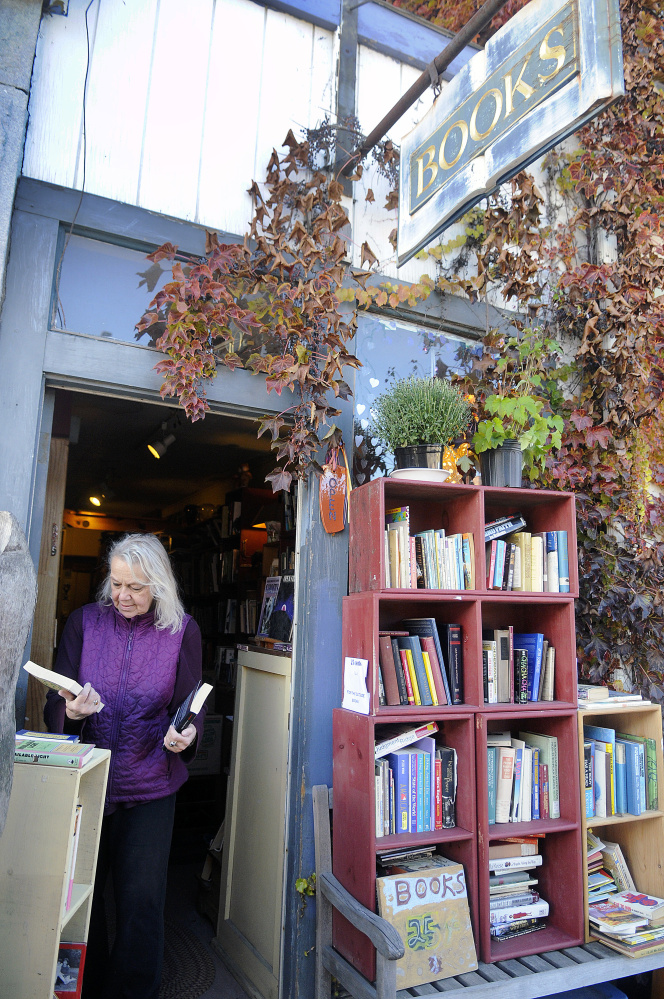 Edda Briggs Thiele sorts titles Monday at RiverBooks in Hallowell, which she is closing at the end of the month.  Briggs Thiele has operated the tiny 24-year-old business on the honor system, with clients leaving money behind for books the selected.