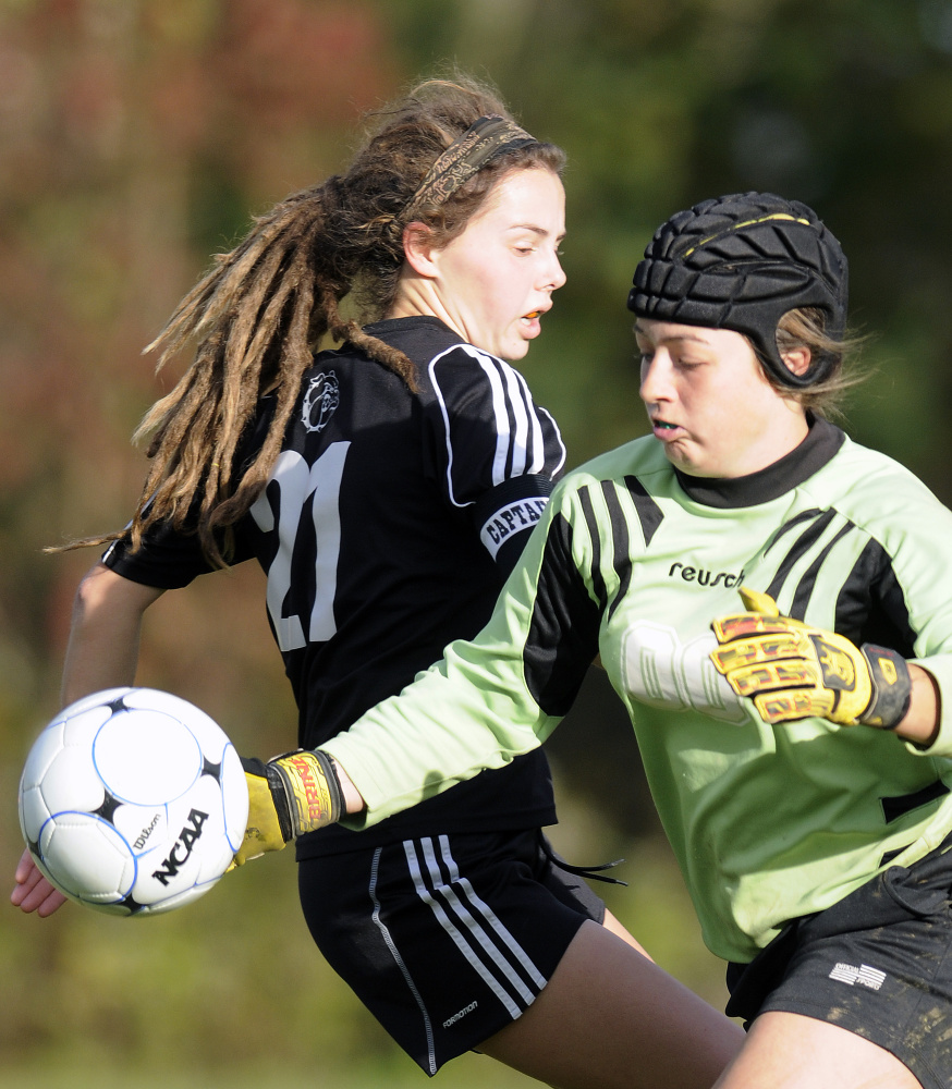 Staff photo by Andy Molloy 
 Hall-Dale High School's Signe Lynch, left, chases a shot that Monmouth keeper Mikayla Cameron knocked away during a Class C South quarterfinal game Tuesday afternoon.