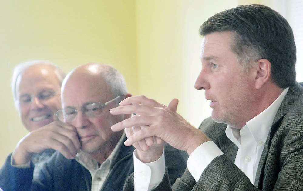 Patrick Keliher, right, commissioner of the Department of Marine Resources, announces Tuesday that Gov. Paul LePage authorized the release of some funds for the Land for Maine’s Future program during a board meeting of the agency in Augusta. Keliher sits on the board with Jim Norris, left, and William Vail, second from left.