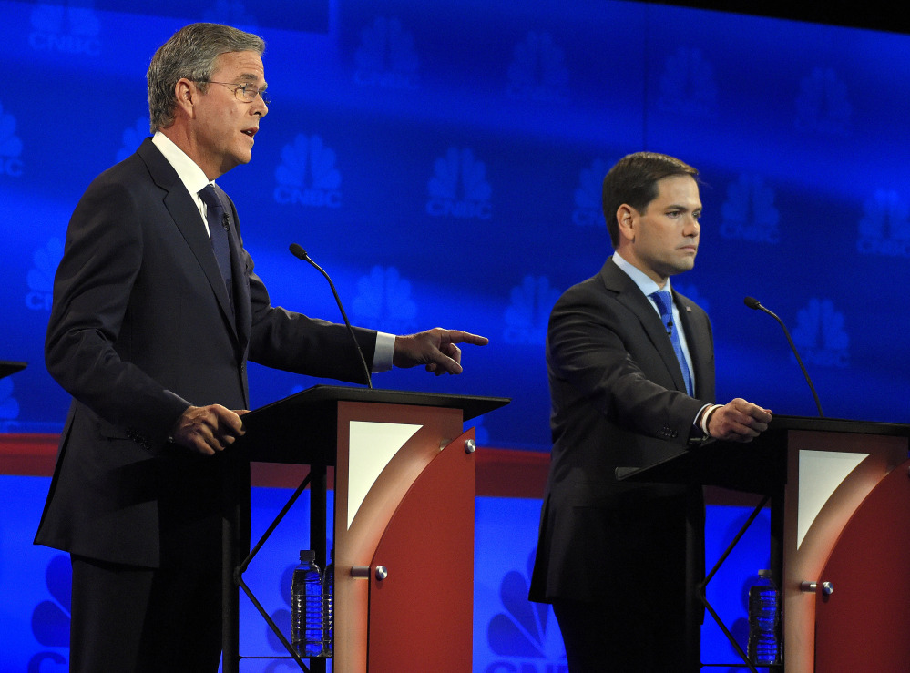 Jeb Bush speaks as Marco Rubio listens during the debate at the University of Colorado.
