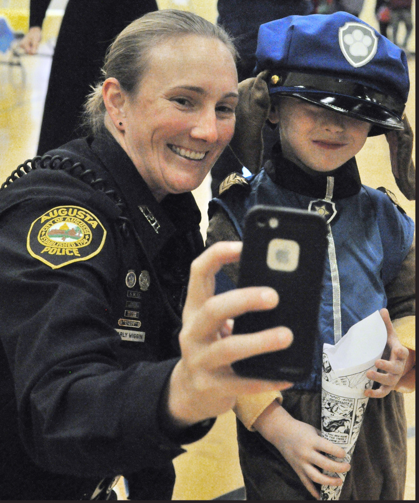 Augusta Police Department School Resource Officer Carly Wiggin takes a photo with Cole Giuffrida who is wearing a Paw Patrol costume during a Lights on After School event last week at the Kennebec Valley YMCA in Augusta. Wiggin, who is stationed at Cony High School, also visits other schools throughout the Augusta system as she works to build relationships with students.