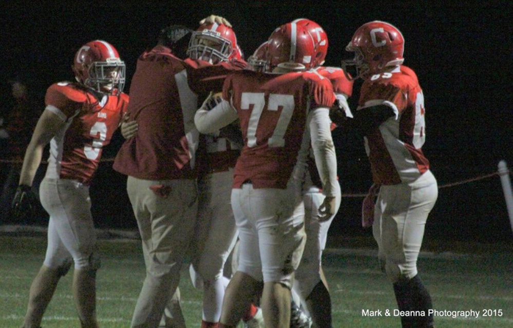 Cony coach B.L. Lippert and the rest of the Rams celebrate with Lucas Tyler after Tyler made an interception against Gardiner on Friday in Augusta.