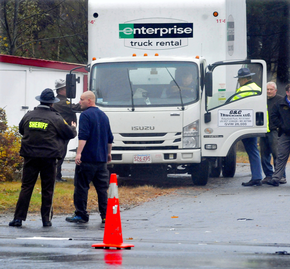 MADISON,ME.-October 29: Police speak with truck driver Harry Cragin, second from left,  following a collision with a vehicle at the intersection of Route 148 and Old County Road in madison on Thursday, October 29, 2015. (Photo by David Leaming/Staff Photographer)