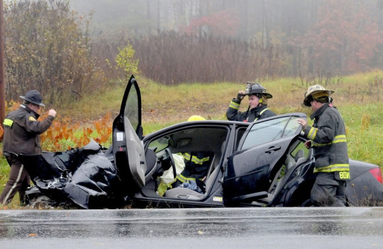 Madison firefighters and police inspect the wreckage of a car at the intersection of Route 148 and Old County Road in Madison that left the female driver with serious injuries on Thursday.  