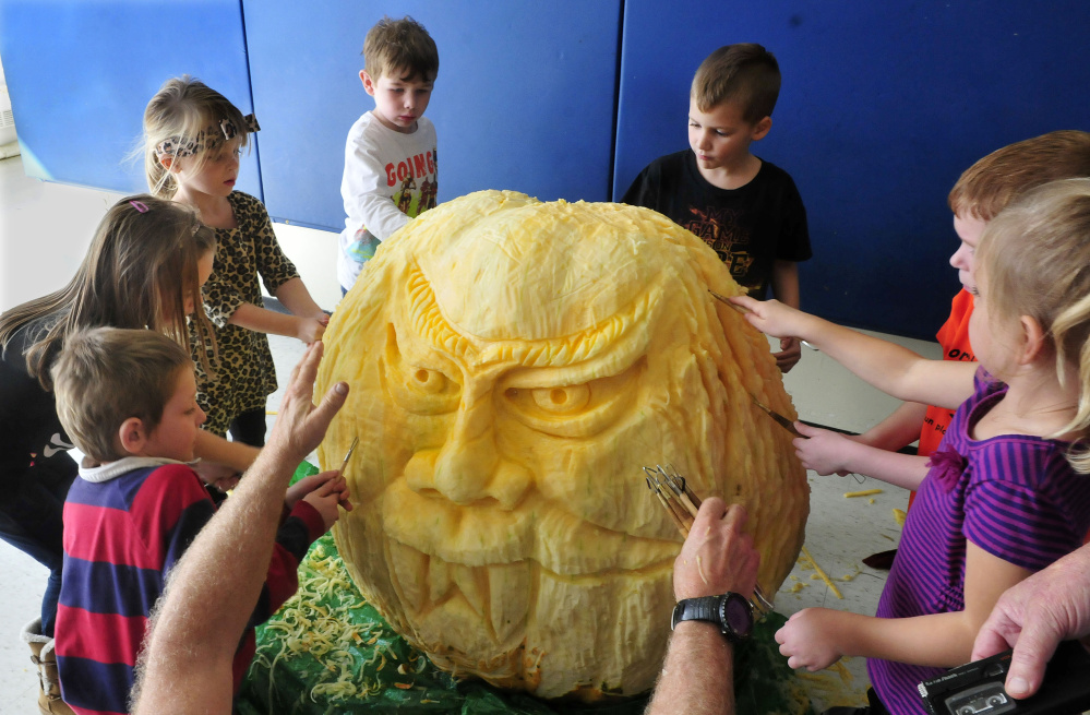 Students at North Elementary School in Skowhegan had their hands full carving a face on a 400-pound pumpkin on Thursday.