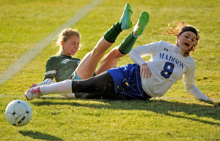 Madison’s Marah Hall (9) slide tackles Waynflete’s Ava Farrar (2) during a Class C South semifinal game Friday in Madison.