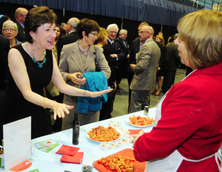 U.S. Sen. Susan Collins, left, talks with Backyard Farms employee Beth Driggs about the tomatoes grown in Madison that were available for sampling before the Maine State Chamber of Commerce dinner on Friday at the Augusta Civic Center.