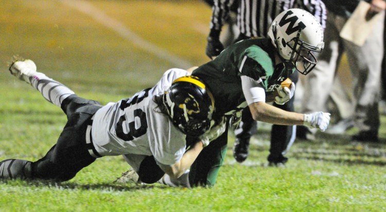 Maranacook linebacker Zach Lacasse, left, tackles Winthrop/Monmouth running back Nate Scott during a Campbell Conference Class D quarterfinal game against Friday night at Maxwell Field in Winthrop.