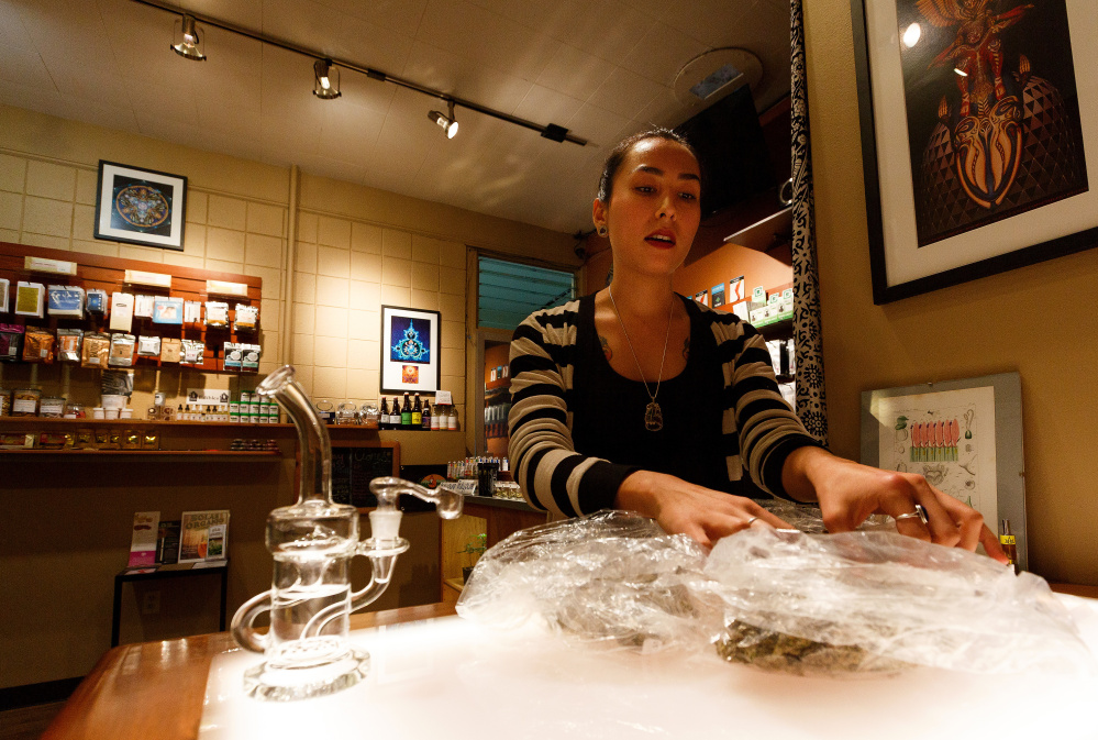 Esther Aldrich looks through bags of cannabis buds at Amazon Organics, a pot dispensary in Eugene, Ore., on Monday as she prepares for legalization.