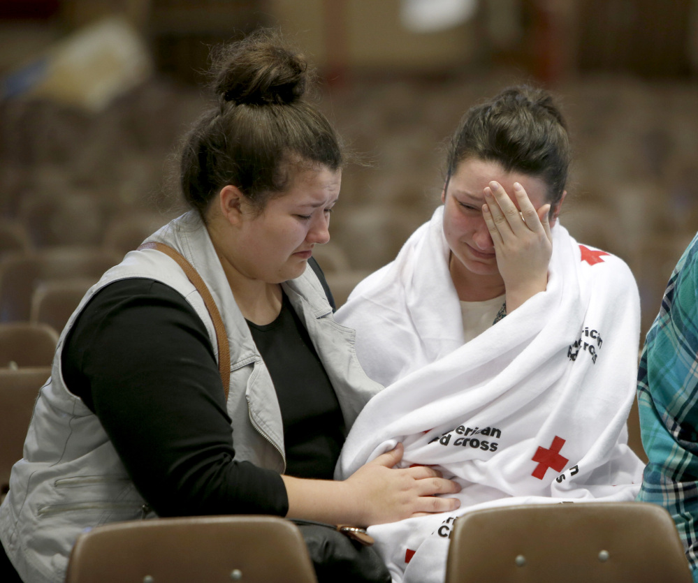 Hannah Miles, right, sits with her sister Hailey after Hannah was reunited with her family in Roseburg, Oregon, on Thursday after a deadly shooting at Umpqua Community College.