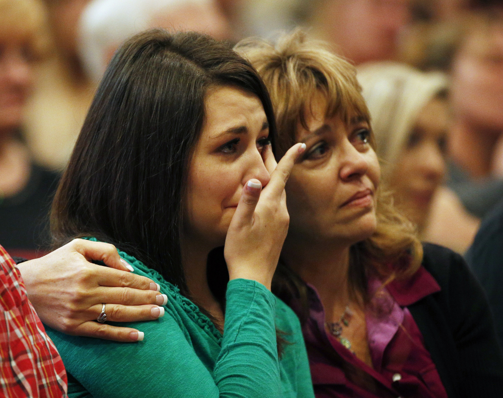 Lacey Scroggins, left, is comforted by her mother, Lisa Scroggins, during a church service Sunday in Roseburg, Ore. 
The Associated Press