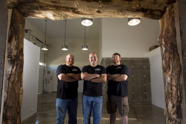 Fore River Brewing Co. co-founders Alex Anastasoff, left, John LeGassey and T.J. Hansen, right, stand in their soon-to-be-renovated facility. Once opened, the brewery will join a crowded landscape of beer companies in Maine.