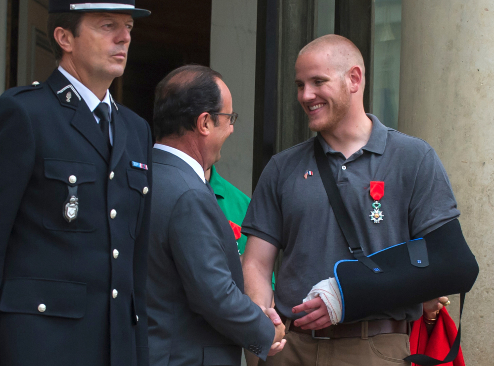 French President Francois Hollande shakes hands with U.S. Airman Spencer Stone outside the Elysee Palace in Paris after awarding Stone the French Legion of Honor.