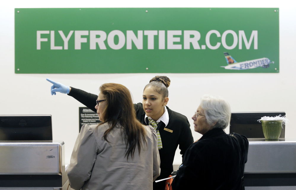 A Frontier Airlines employee directs passengers at Cleveland Hopkins International Airport. Much of the grousing about discount airlines is tied to dismal on-time records. Numerous fees and tightly packed seats also draw criticism.