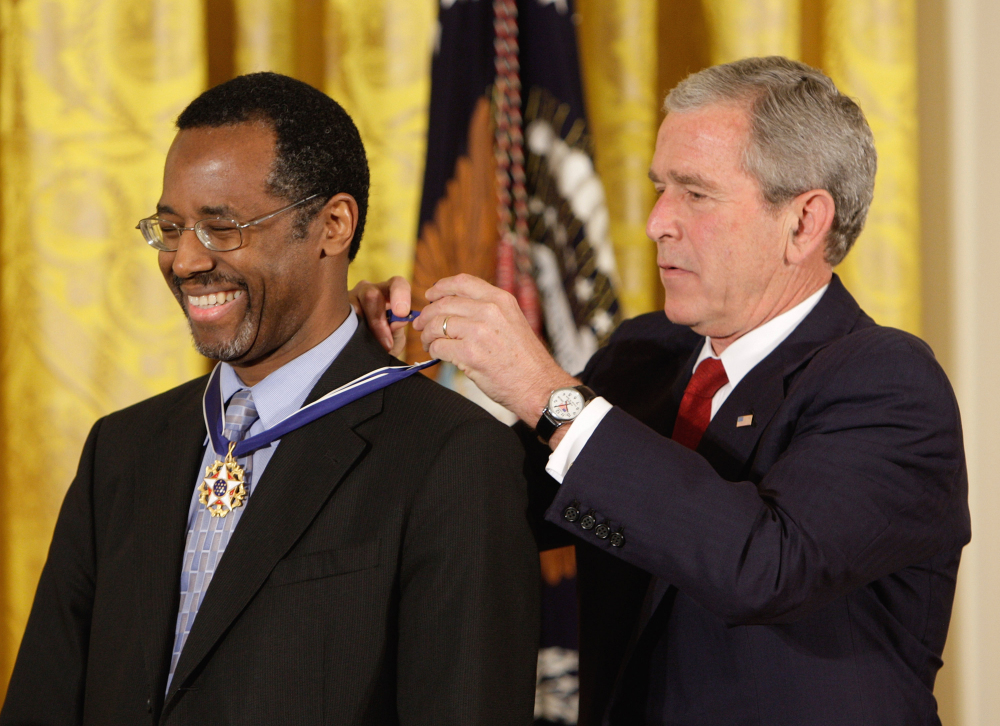 In this June 19, 2008, file photo, President George W. Bush places the Presidential Medal of Freedom on Johns Hopkins University’s then-director of pediatric neurosurgery Dr. Ben Carson, as he takes part in a ceremony for the 2008 recipients of the Presidential Medal of Freedom, in the  East Room at the White House in Washington.