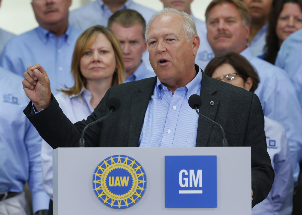 In this July 13, 2015, file photo, United Auto Workers President Dennis Williams speaks as General Motors CEO Mary Barra, background left, listens during a ceremony to mark the opening of contract negotiations in Detroit.