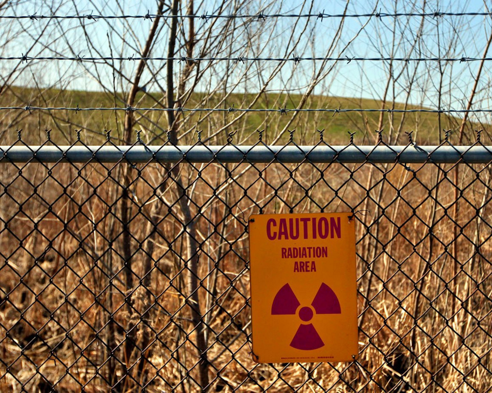 A radiation warning hangs at the West Lake Landfill in Bridgeton, Mo., where officials fear that smoldering embers could spread to where nuclear waste has long been buried.