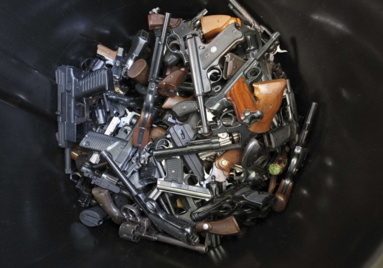 Handguns that were turned in by their owners are collected in a trash bin at a gun buyback program in Los Angeles following the mass shooting at Sandy Hook Elementary School in Connecticut in 2012.