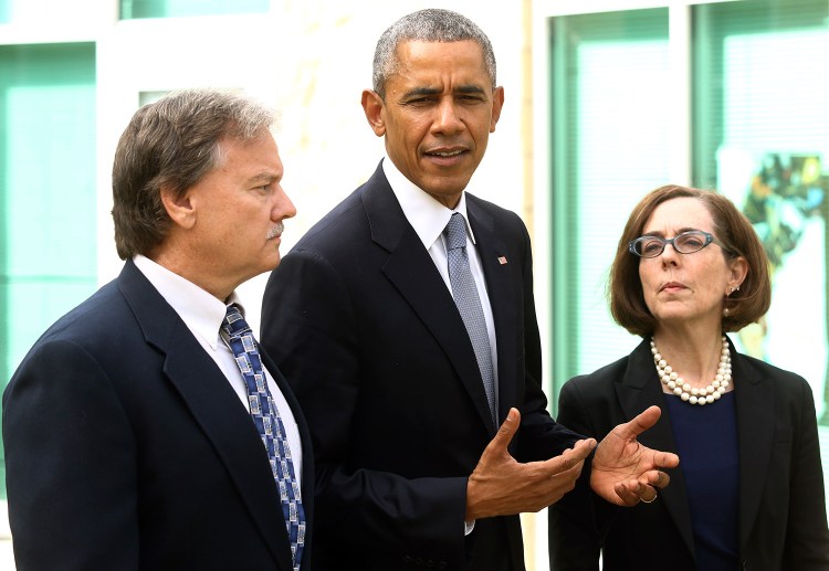 Roseburg Mayor Larry Rich, left, and Oregon Gov. Kate Brown look on Friday as President Obama makes a statement at Roseburg High School after speaking with families of victims of the Umpqua Community College shooting. He said, "We’re going to have to come together as a country to see how we can prevent these issues from taking place."
Michael Sullivan/The News-Review via AP
