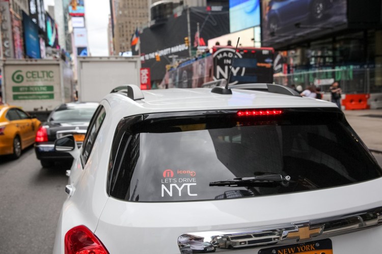 A car from GM's "Let's Drive NYC" car-sharing program sits in traffic near Times Square. In the new GM business venture, announced in an investor call on Thursday, October 1, 2015, customers can use a mobile app to reserve a shared  vehicle and access parking in 200 garages citywide.